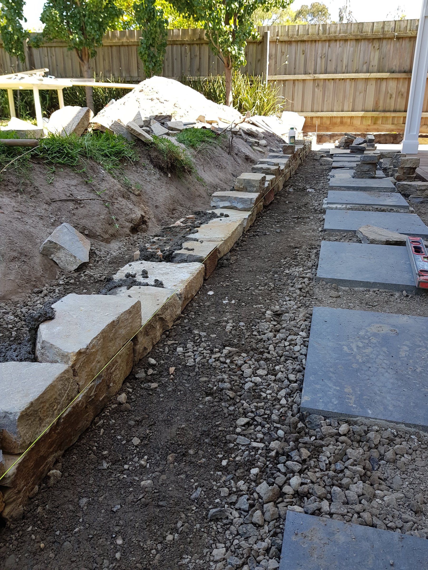 Stone wall and steppers going in together