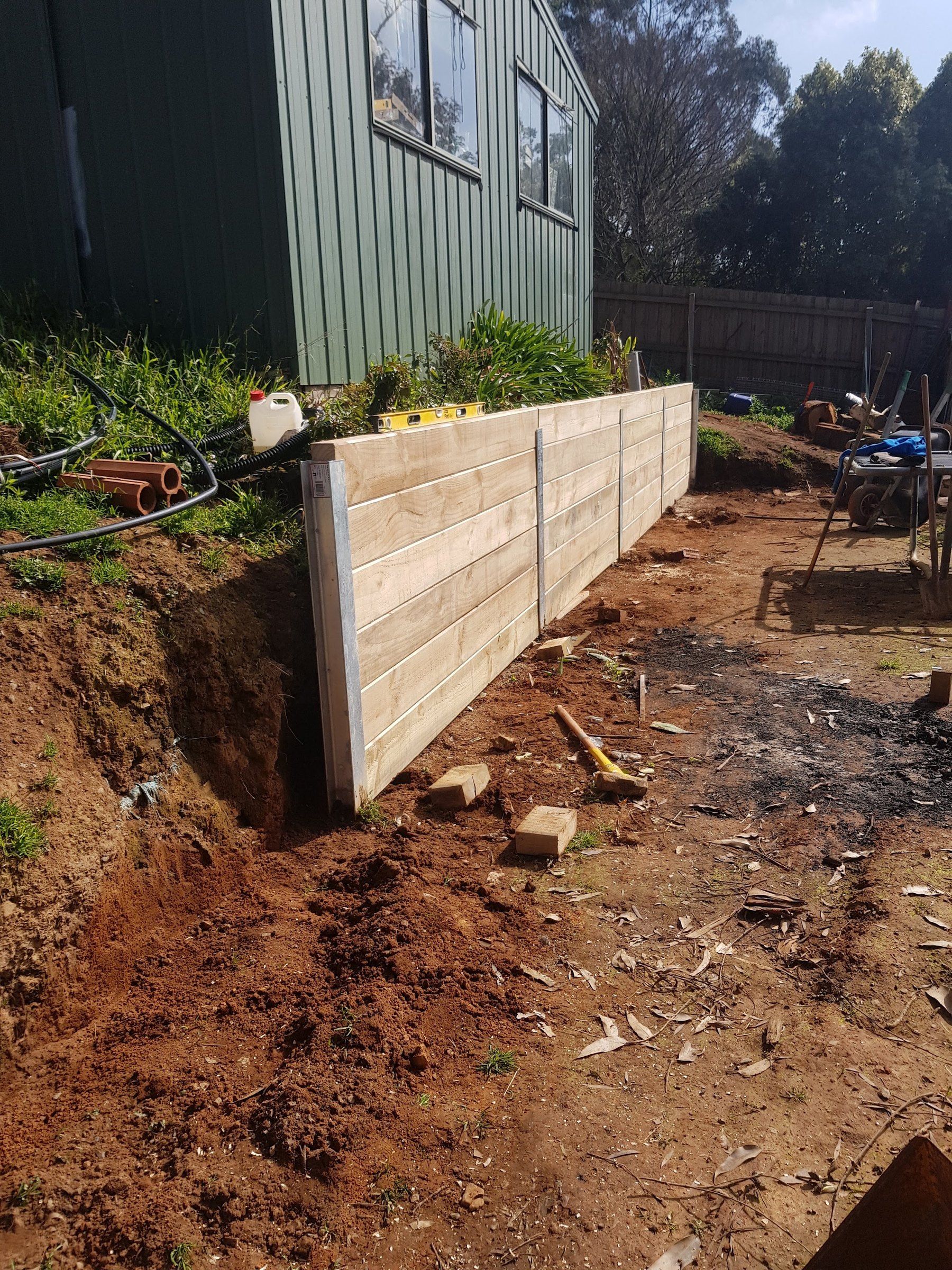 Timber sleeper wall on a cut beside the shed