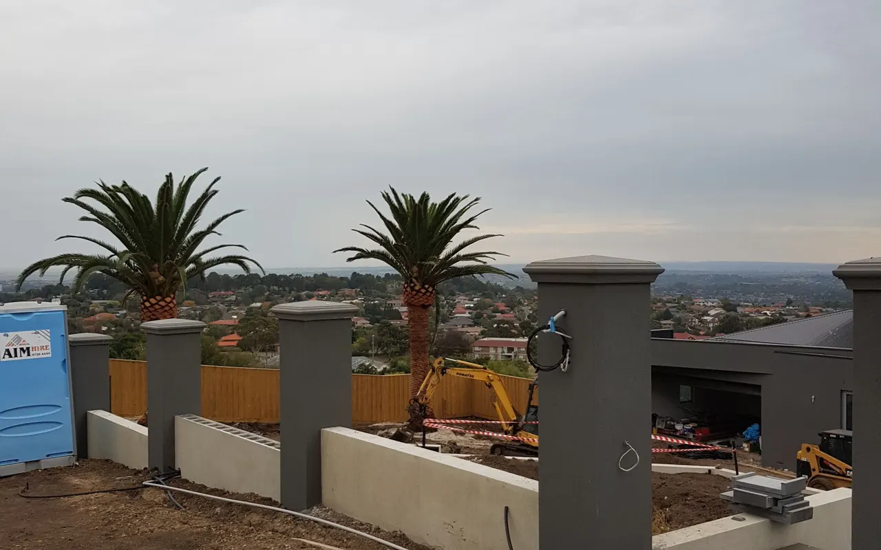 Full length concrete sleeper retaining wall holding a cut level above a lawn