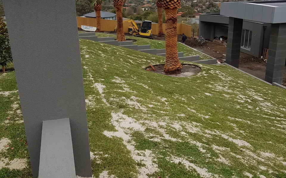 Excavated residential site being cut to level before landscape construction